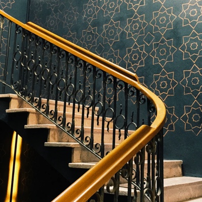 picture of staircase going up with yellow hand rail